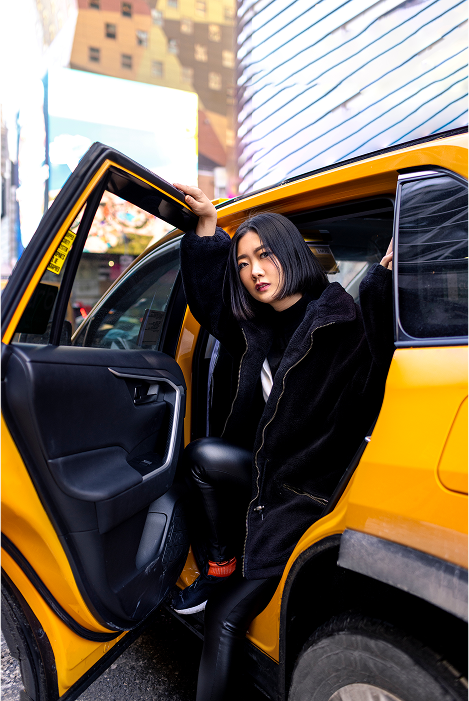 Woman getting out of yellow taxi